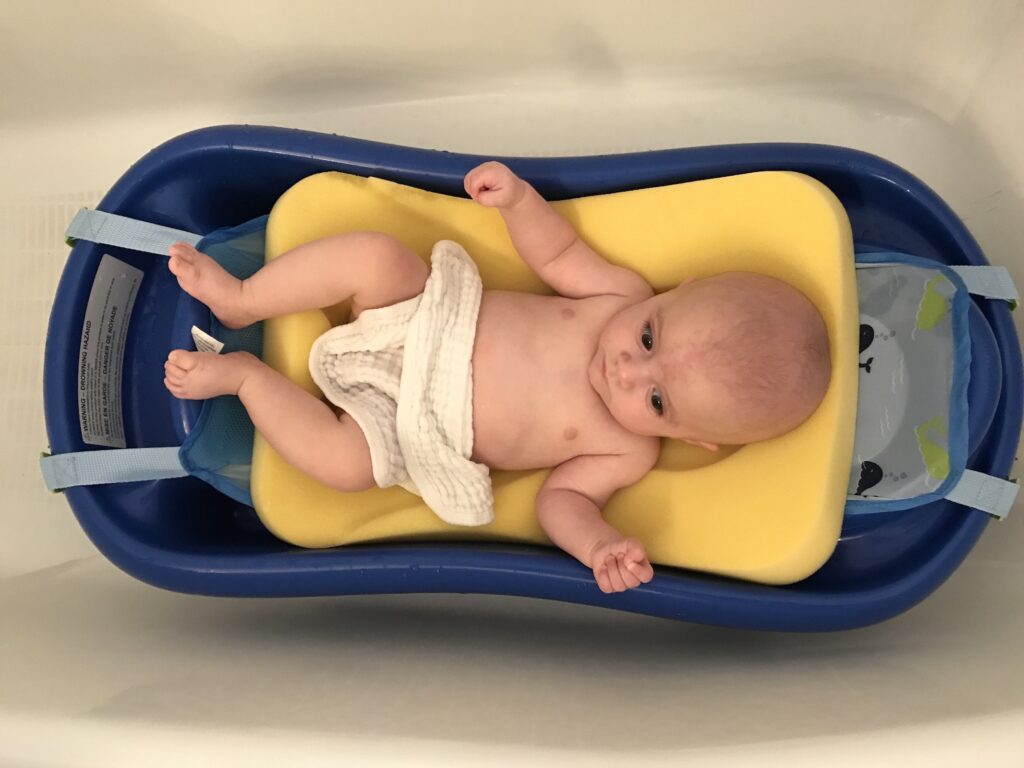 bath time in the infant plastic bathtub with removable sling
