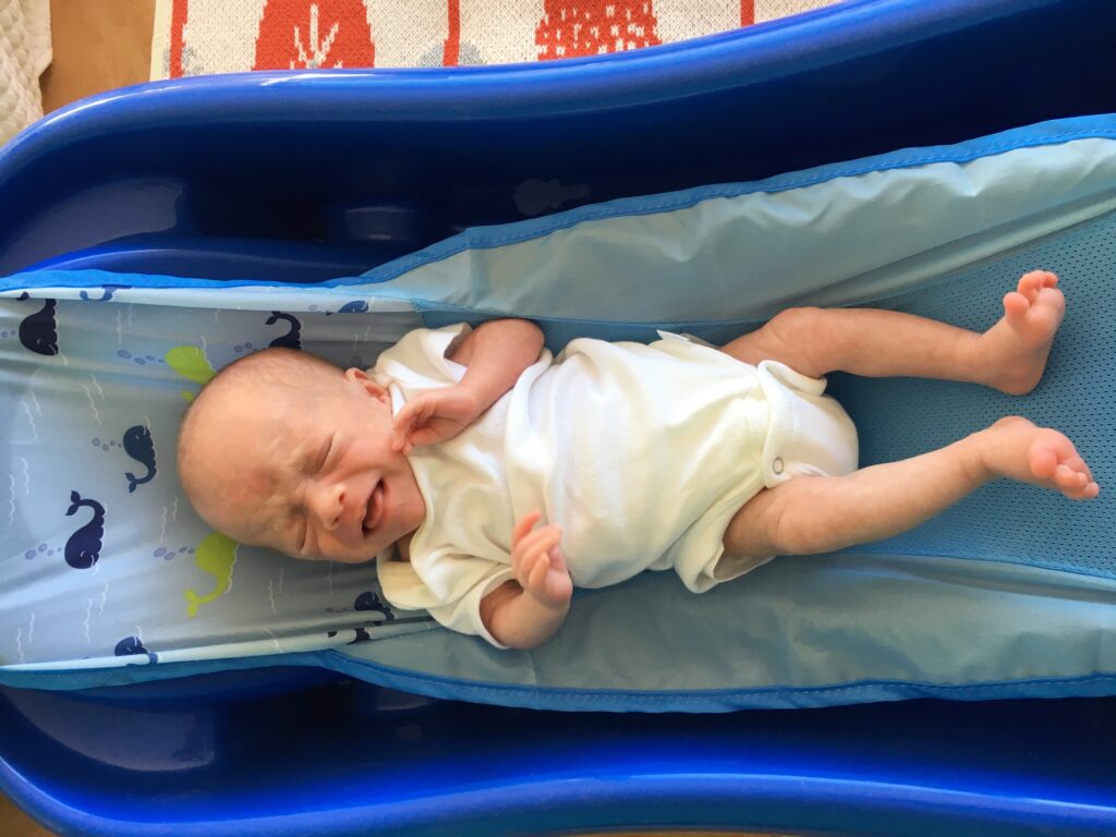 Premature three week old infant trying out the first years sure comfort deluxe bathtub