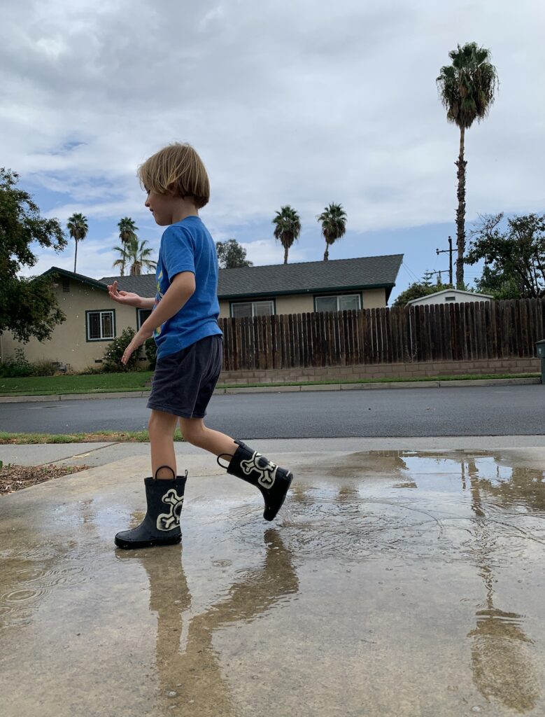 Warm summer day for shorts and rain boots and kids splashin in puddles