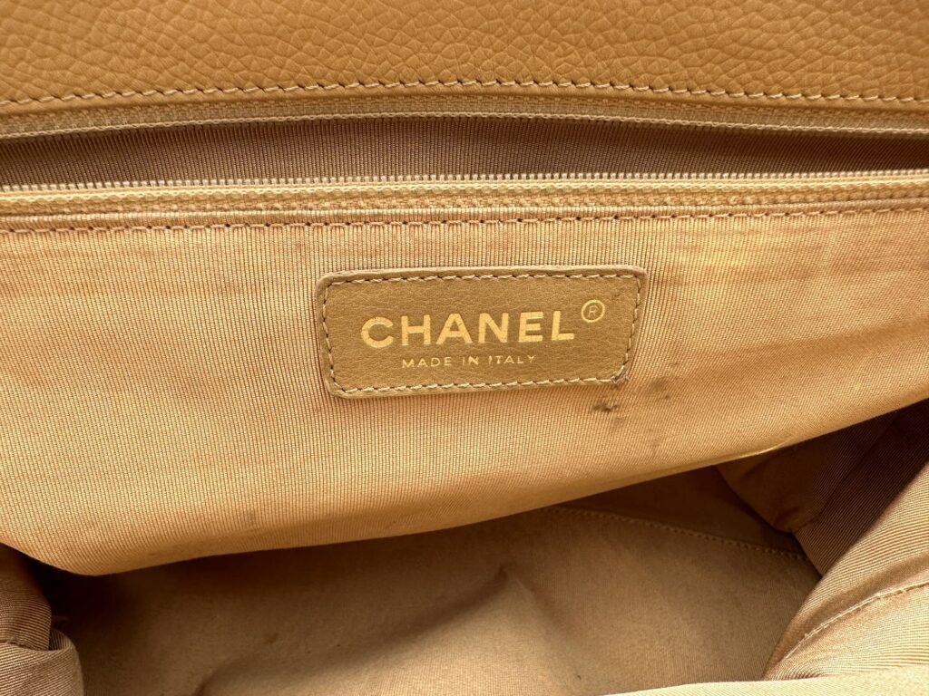 Close up of a Vintage CHANEL Cerf Executive Tote Bag CHANEL Made in Italy Registered Trademark Logo Leather Patch Sewn inside the handbag zip pocket embossed with gold stamp paint