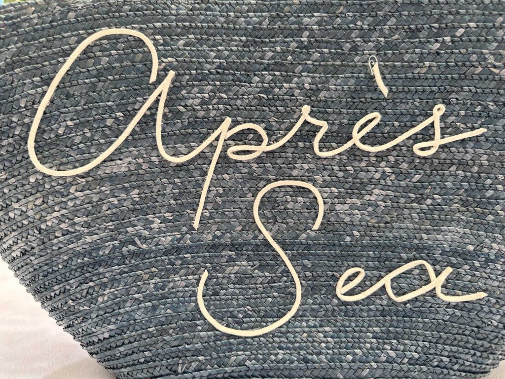 3D embroidered glued slogan on the front of a straw beach bag