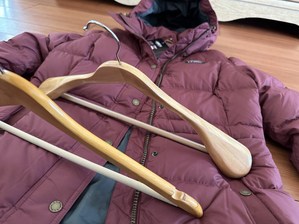 Invest in wooden hangers for your winter coats. Opt for thicker hangers to keep your puffer coat looking great. Check out the difference between regular wood hangers and heavy duty coat hangers.