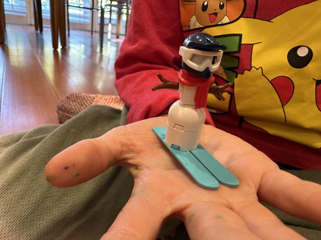 Cute Lego Skiing Snowman Build with a snow helmet and ski goggles and the cutest red scarf. Blue skis and Lego wooden Branches as arms top it off.