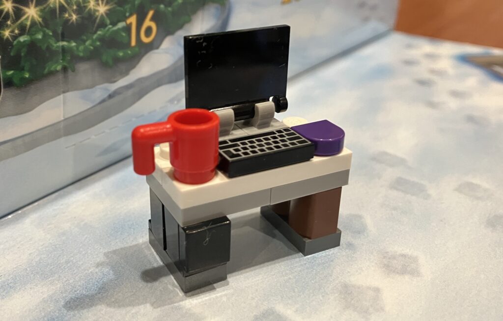 Day #12 of the LEGO City Advent Calendar 2023 Had a tiny build of a desk some say it's a gamers set up of a laptop or computer a purple mouse and of course a huge red mug of coffee or maybe tea or something stronger