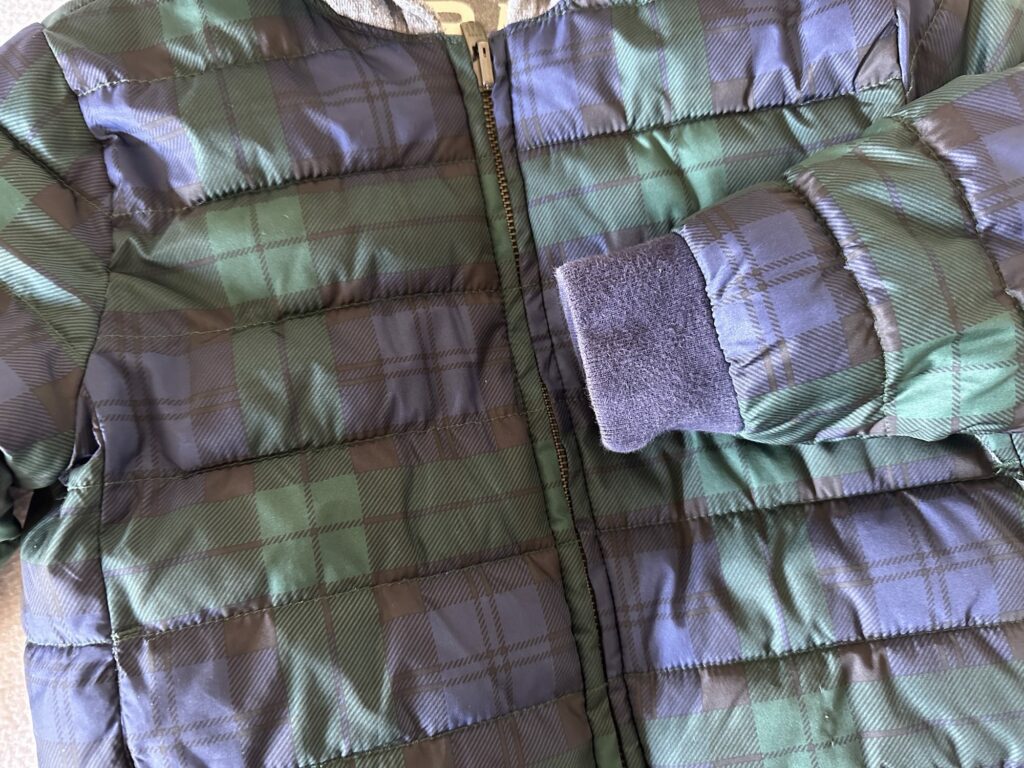 Close up of the banding wear and tear on the GAP Puffer jacket for kids