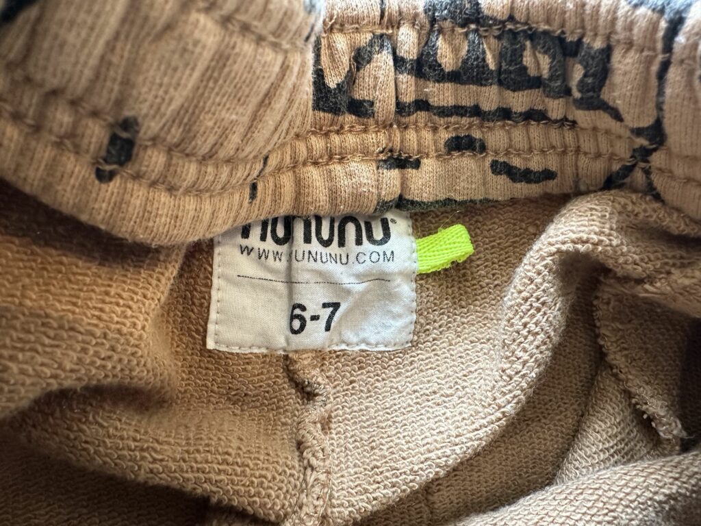 Nununu Size Tag Sewn into the back of the pants with a neon yellow green tab size 6-7