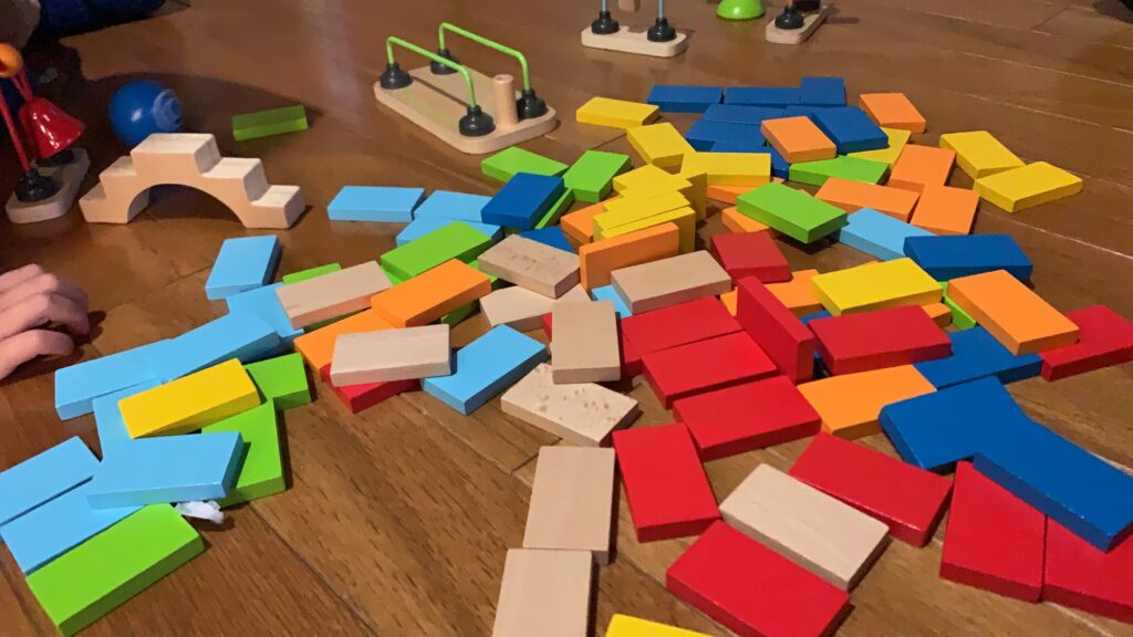 HAPE Wooden Dominoes for Toppling and Setting up Obstacles feature many colors to help with STEM and STEAM Activities for young kids and toddlers