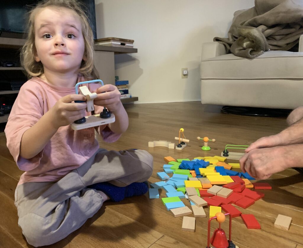 HAPE Dominoes wooden set with bell, log, rotating arm and fidget obstacles. The full review on the blog!