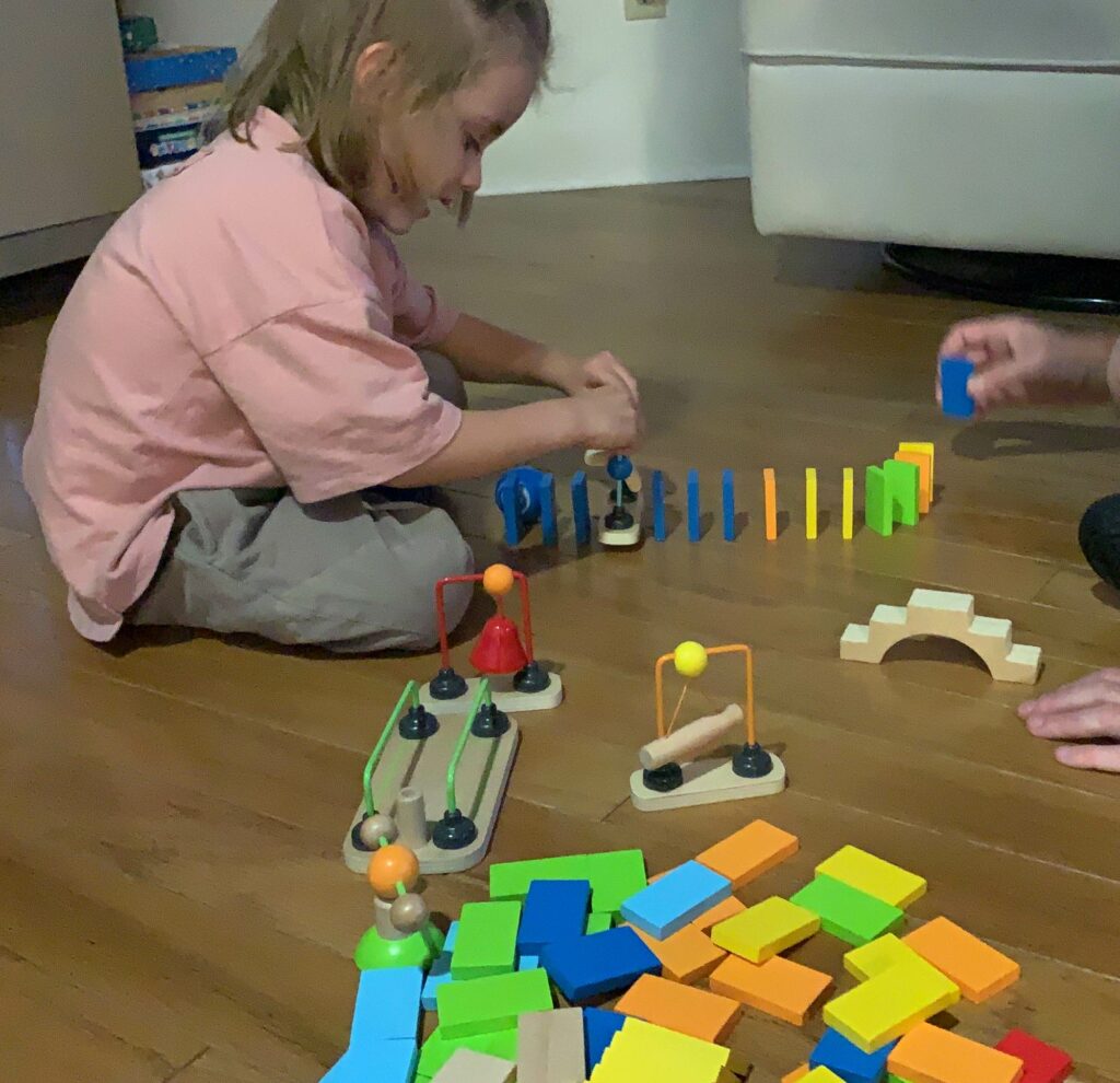 Toddler's first reaction to the Hape Wooden Toppling dominoes with obstacles